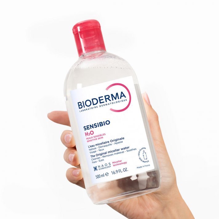 Дівчина тримає у руці Bioderma - Міцелярна вода для чутливої шкіри - Sensibio H2O 